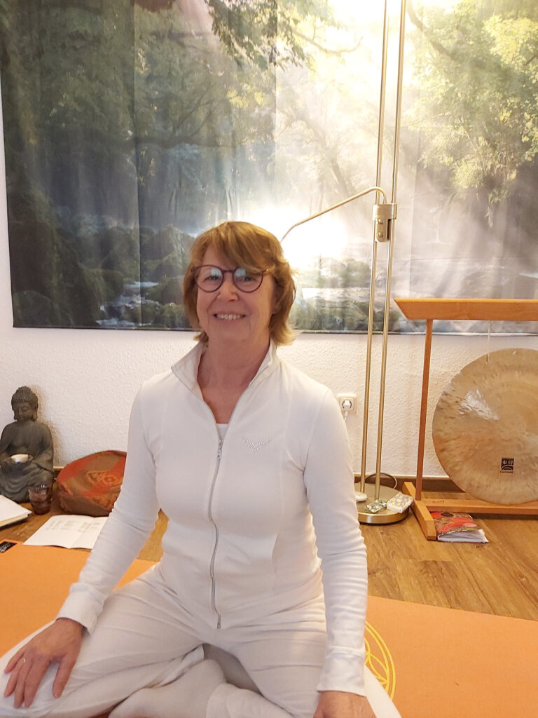 Yoga-Lehrerinnen Heidi Klemm in weißer Sportkleidung im Yoga-Studio in Schmölln